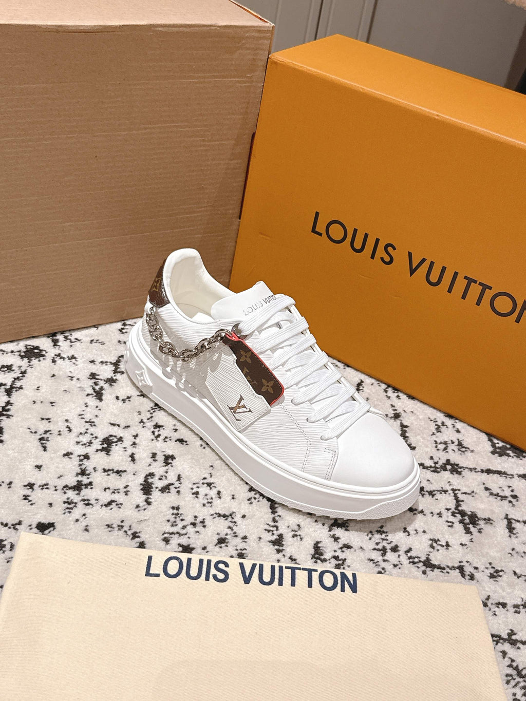 White Louis Vuitton low-top sneakers with lace-up front, silver chain, monogram accent