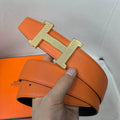 Orange leather belt with gold H buckle and adjustable strap holes