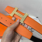 Orange leather belt with gold H buckle and textured strap with holes