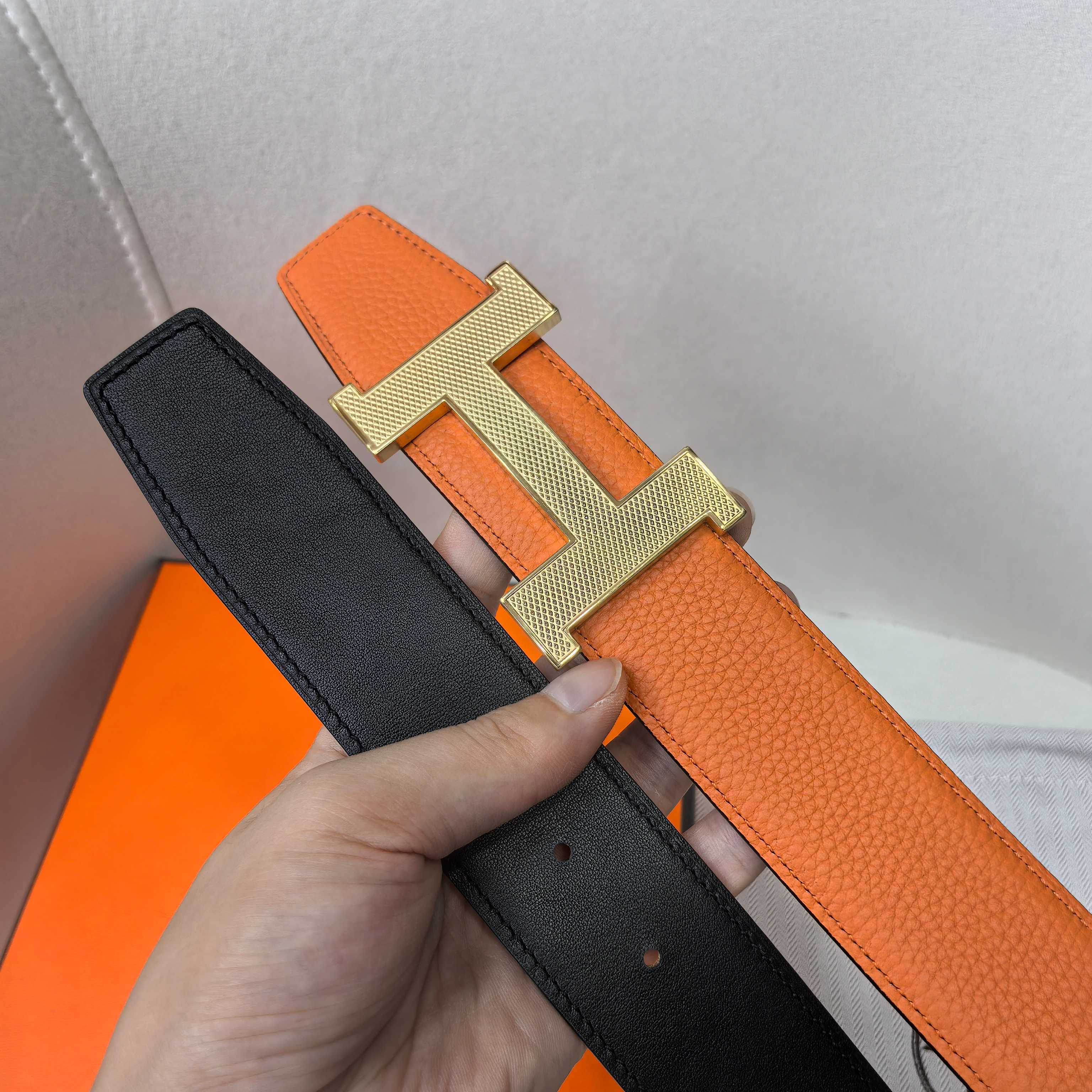 Reversible leather belt showing black strap underside and gold H buckle