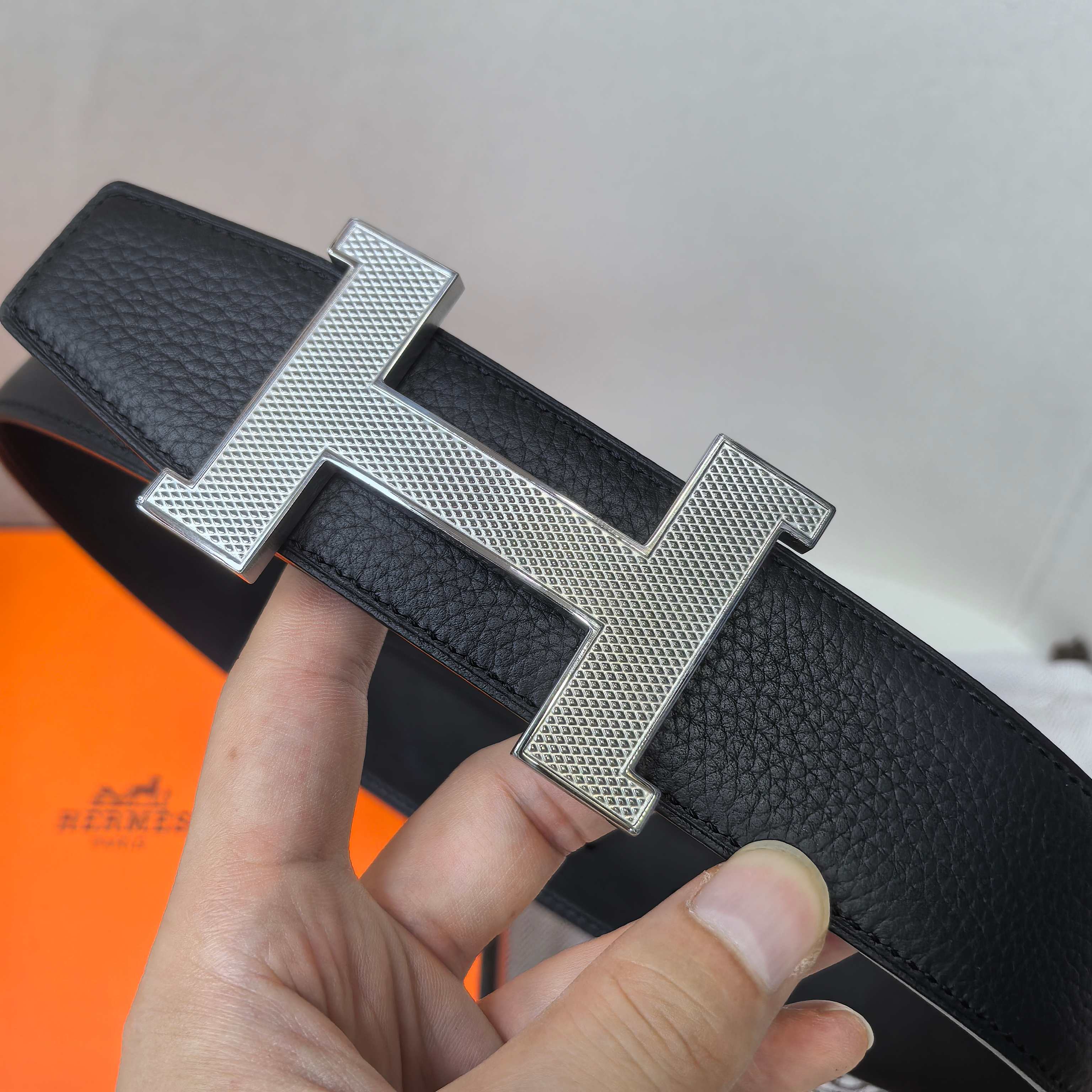 Leather belt with silver H buckle, dark textured strap and stitching detail
