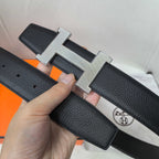 Leather belt with silver H buckle, dark textured strap, loop keeper visible