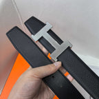 Leather belt with silver H buckle and dark textured strap, edge view