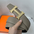 Gray leather belt with gold H buckle and stitched keeper holes