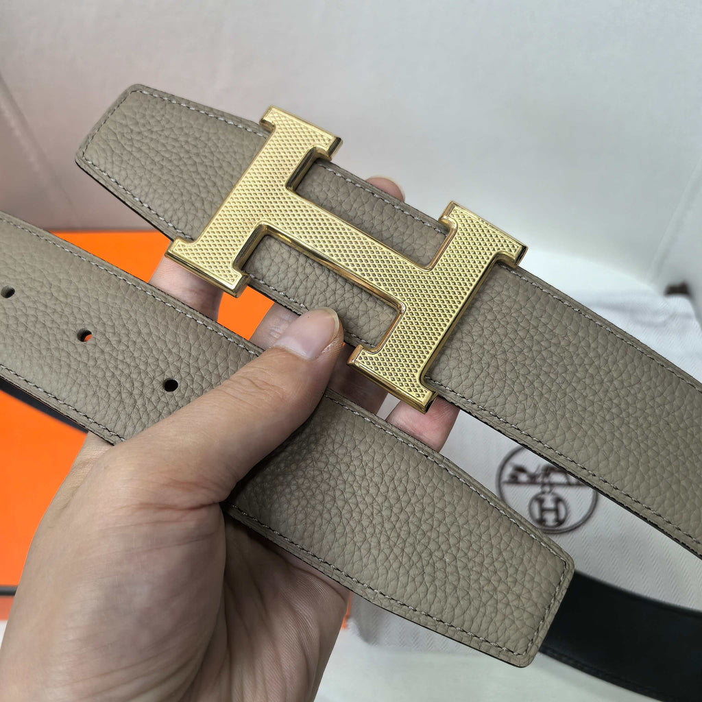 Gray leather belt with gold H buckle and multiple strap holes