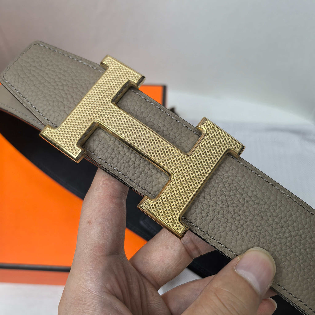 Gray leather belt with gold H buckle and textured leather grain