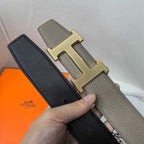 Dark leather belt with gold H buckle, textured finish and keeper holes