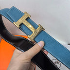 Hermes blue leather belt with gold-tone H buckle; black underside lining visible