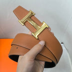 Hermes belt in tan leather with gold-tone double buckle and stitched strap edge.