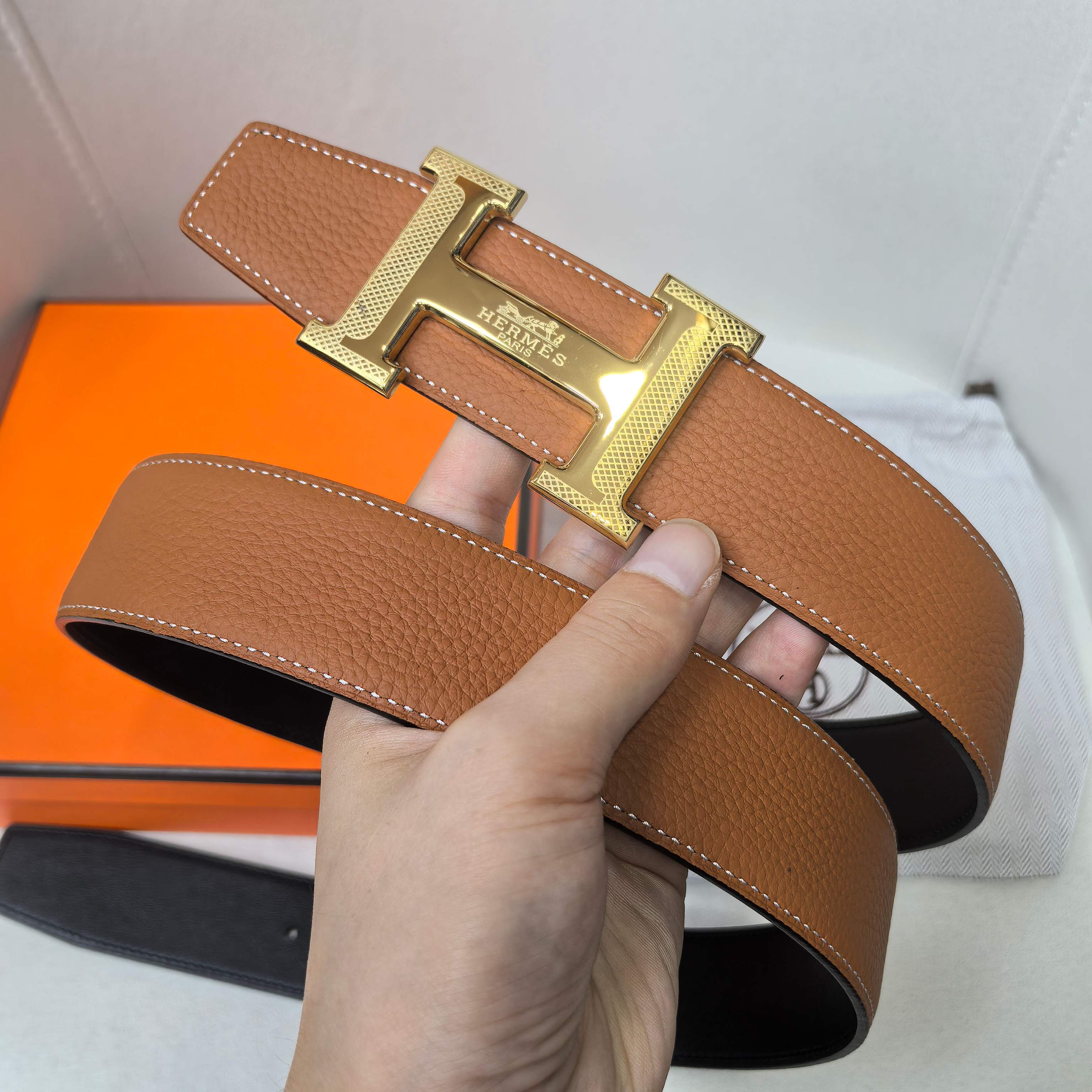 Hermes belt tan leather with gold-tone buckle and contrast stitching on strap.