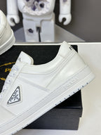 White leather Prada low-top sneaker with logo lettering on the tongue.