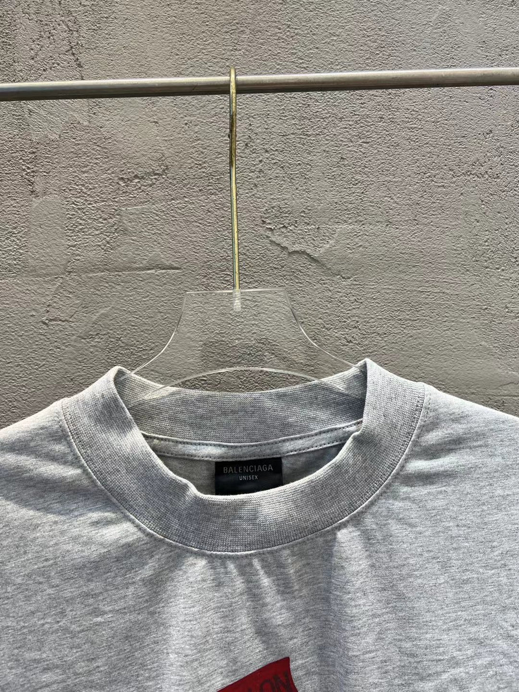 Light gray crewneck T-shirt with small black brand label at the neckline