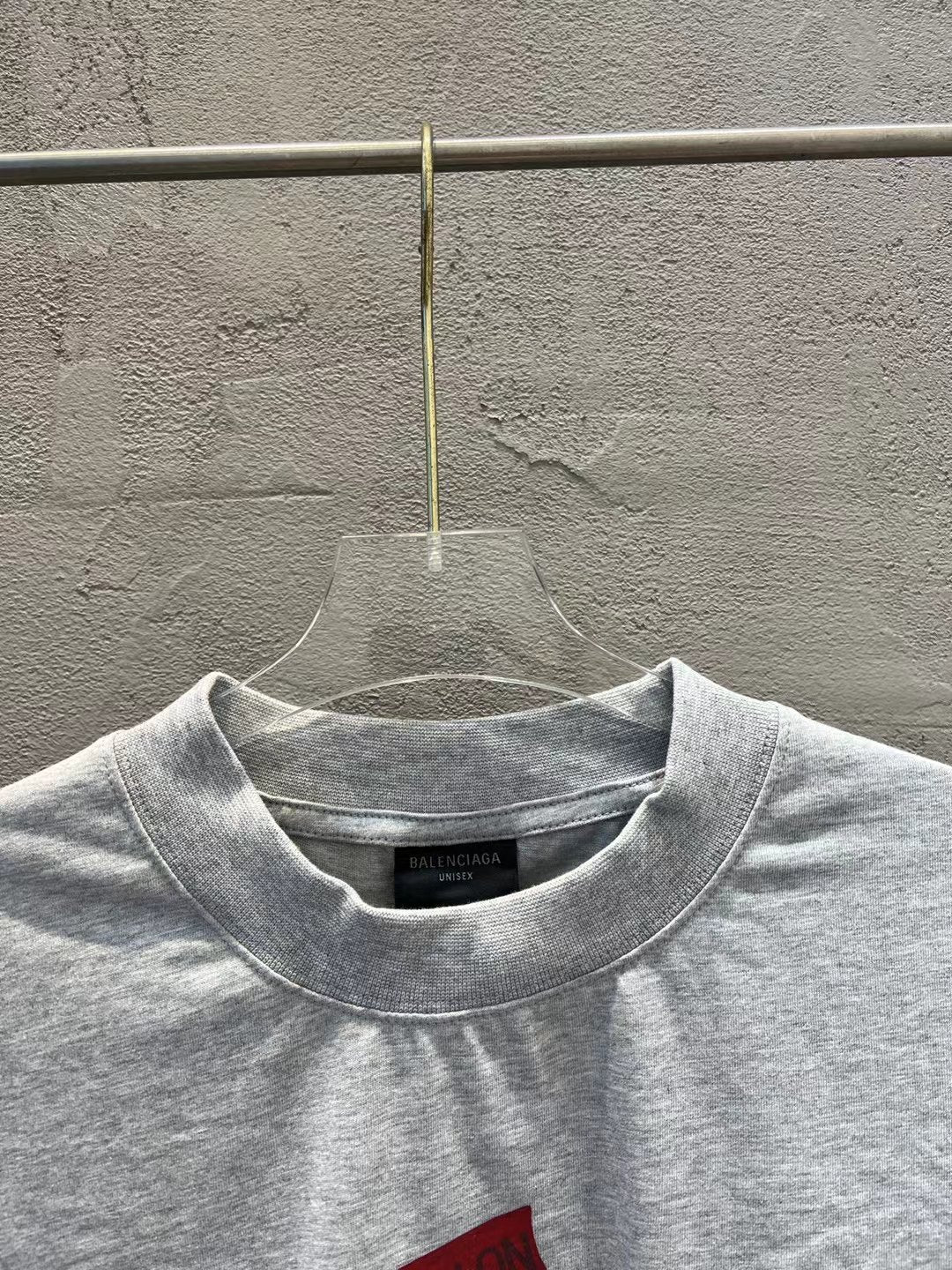 Light gray crewneck T-shirt with small black brand label at the neckline