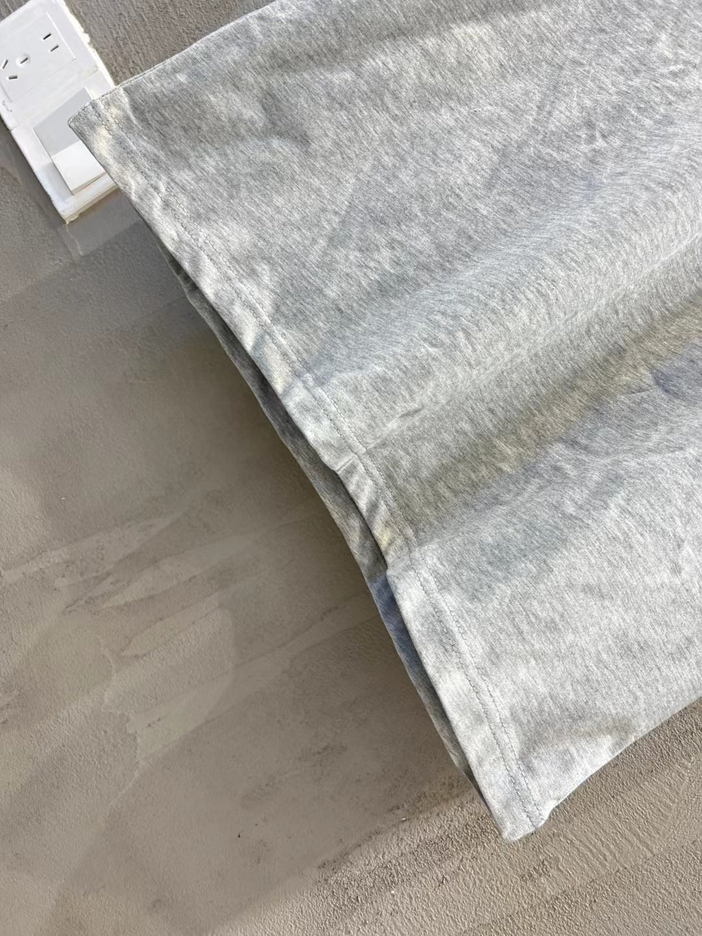 Light gray T-shirt fabric and hem, folded with visible collar edge