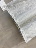 Light gray T-shirt fabric and hem, folded with visible collar edge