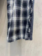 Plaid pants hem detail with stitched edge and textured elastic side trim