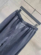 Solid navy pants with elastic waistband, gathered fabric, and wide-leg shape