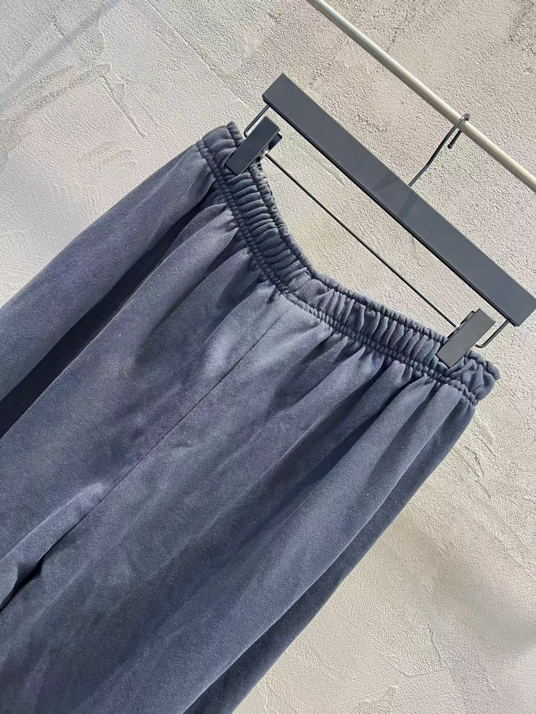 Solid navy pants with elastic waistband, gathered fabric, and wide-leg shape