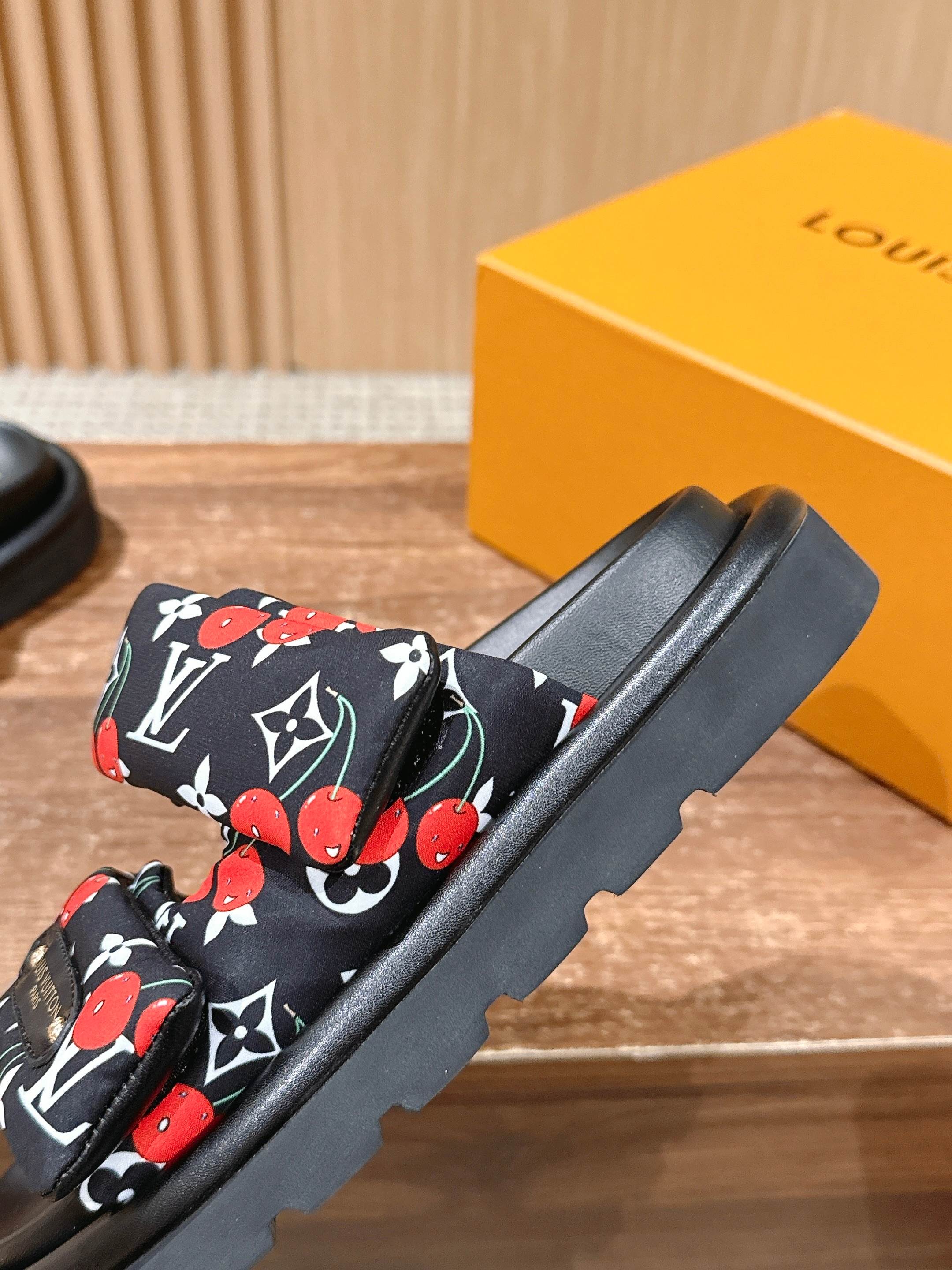 Louis Vuitton slide sandal close-up, black cherry-and-LV patterned straps on black slide base