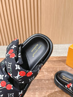 Louis Vuitton slide sandal close-up, black footbed with logo and patterned strap