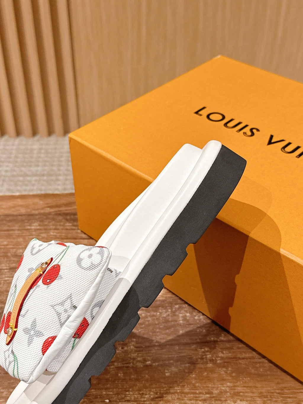 White cherry-print slide sandals with black outsole edge visible