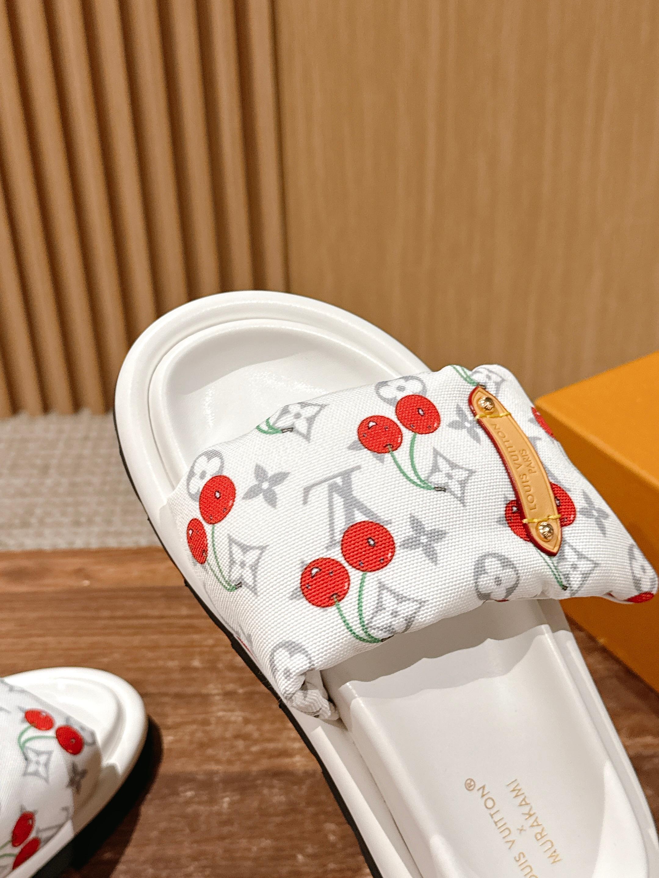 White cherry-print slide sandals close-up of strap and white footbed