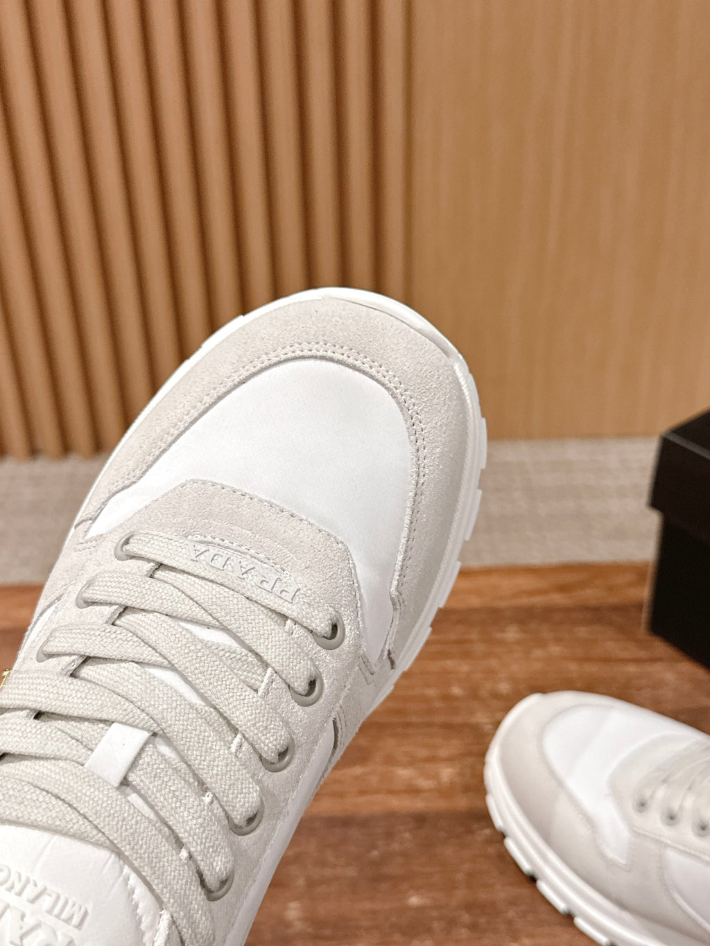 Prada unisex white sneakers close-up, laces and textured fabric upper