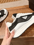 Unisex sneaker with black perforated upper, white laces and PRADA label