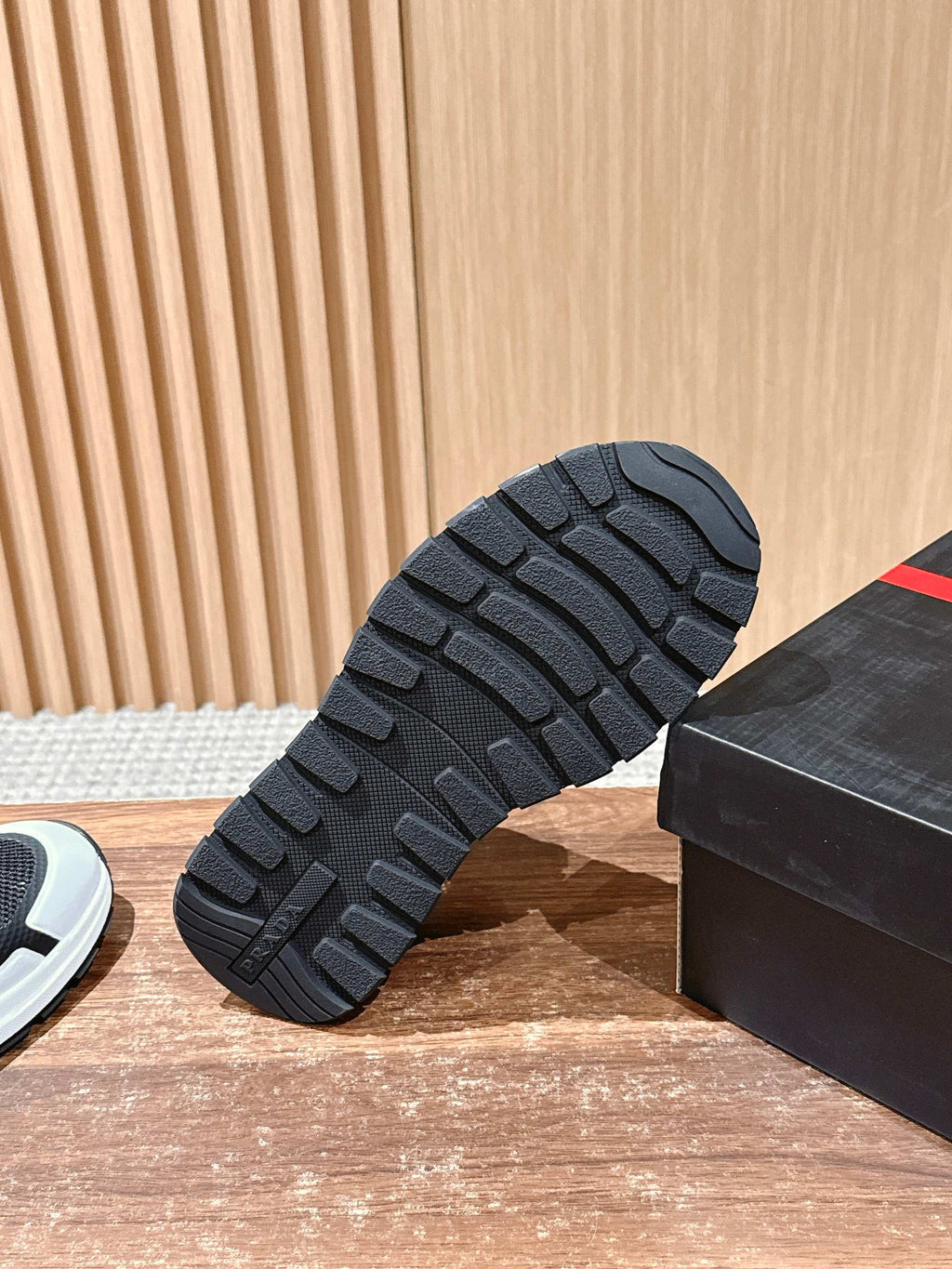 Black rubber sneaker outsole tread next to display box