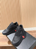 Black lace-up sneakers with logo patch detail and chunky sole, pair on box