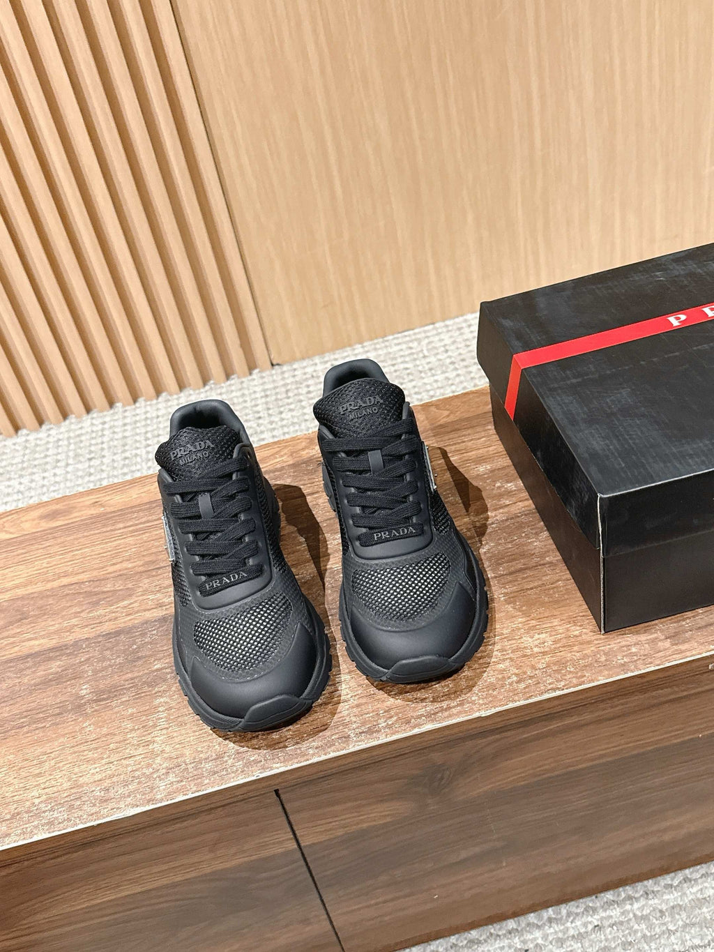 Black lace-up sneakers with textured mesh upper and rubber sole, pair shown