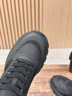 Black sneaker with mesh toe panel and lace-up front, close-up view