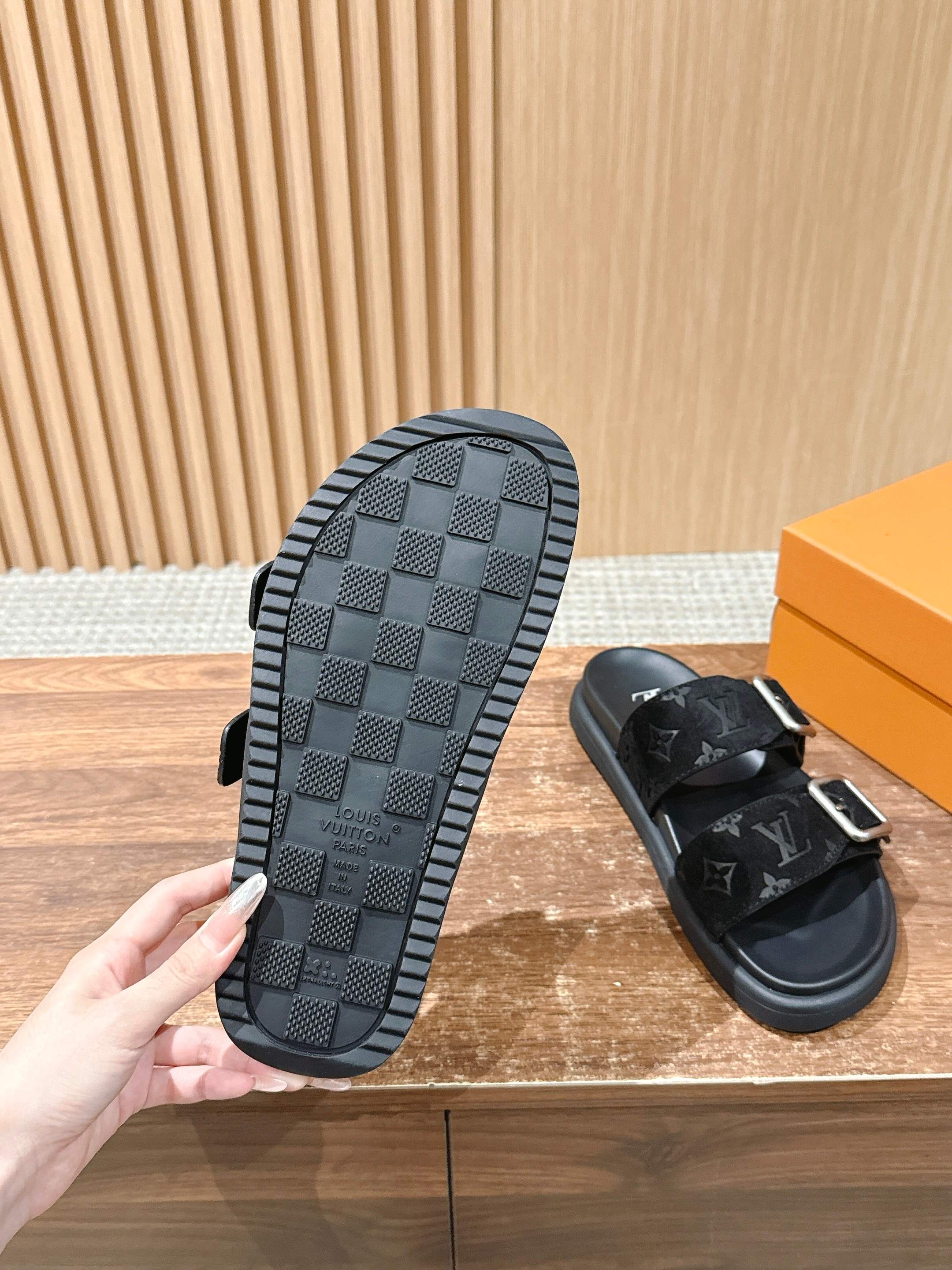 Black monogram rubber outsole of slide sandal with textured checker tread