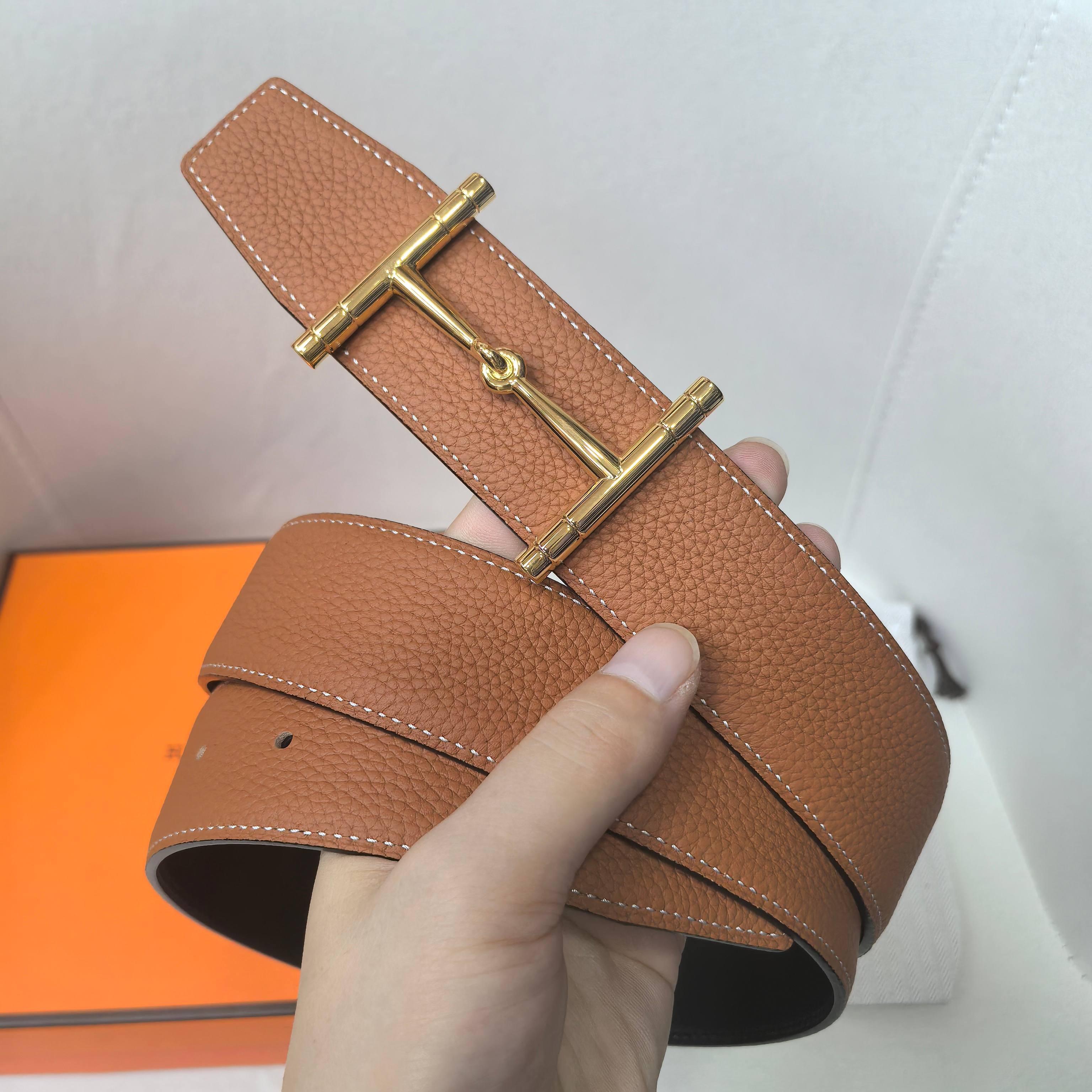 Brown leather belt with gold-tone rectangular buckle and keeper strap, visible holes
