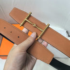Brown leather belt close-up of gold buckle hardware and adjustment holes