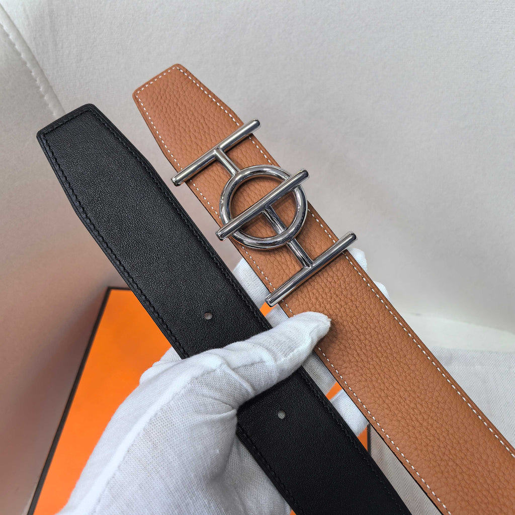 Leather belt with black and tan sides and silver buckle; stitched edges