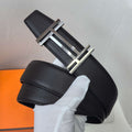 Leather belt with textured black leather and silver-tone metal buckle, close-up