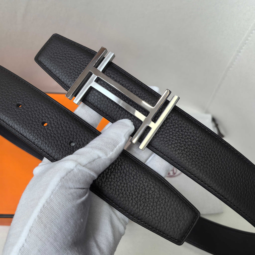 Leather belt with textured black leather and silver-tone buckle, detail view