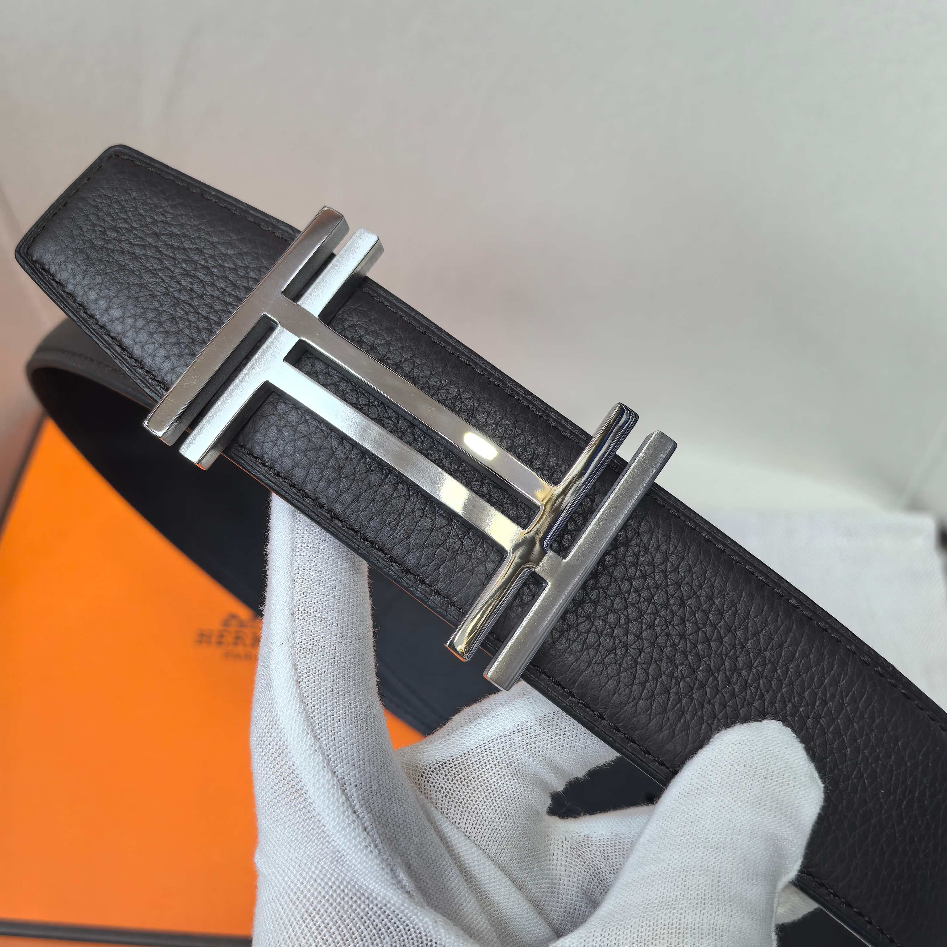 Leather belt with textured black leather and silver-tone buckle, front view