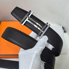 Leather belt with textured black strap and silver-tone buckle, angled view