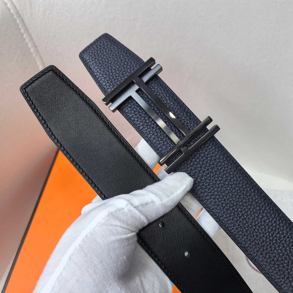 Navy leather belt with silver-tone buckle and black keeper tab