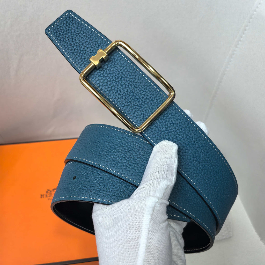 Leather belt, blue textured leather with gold buckle and pin closure.