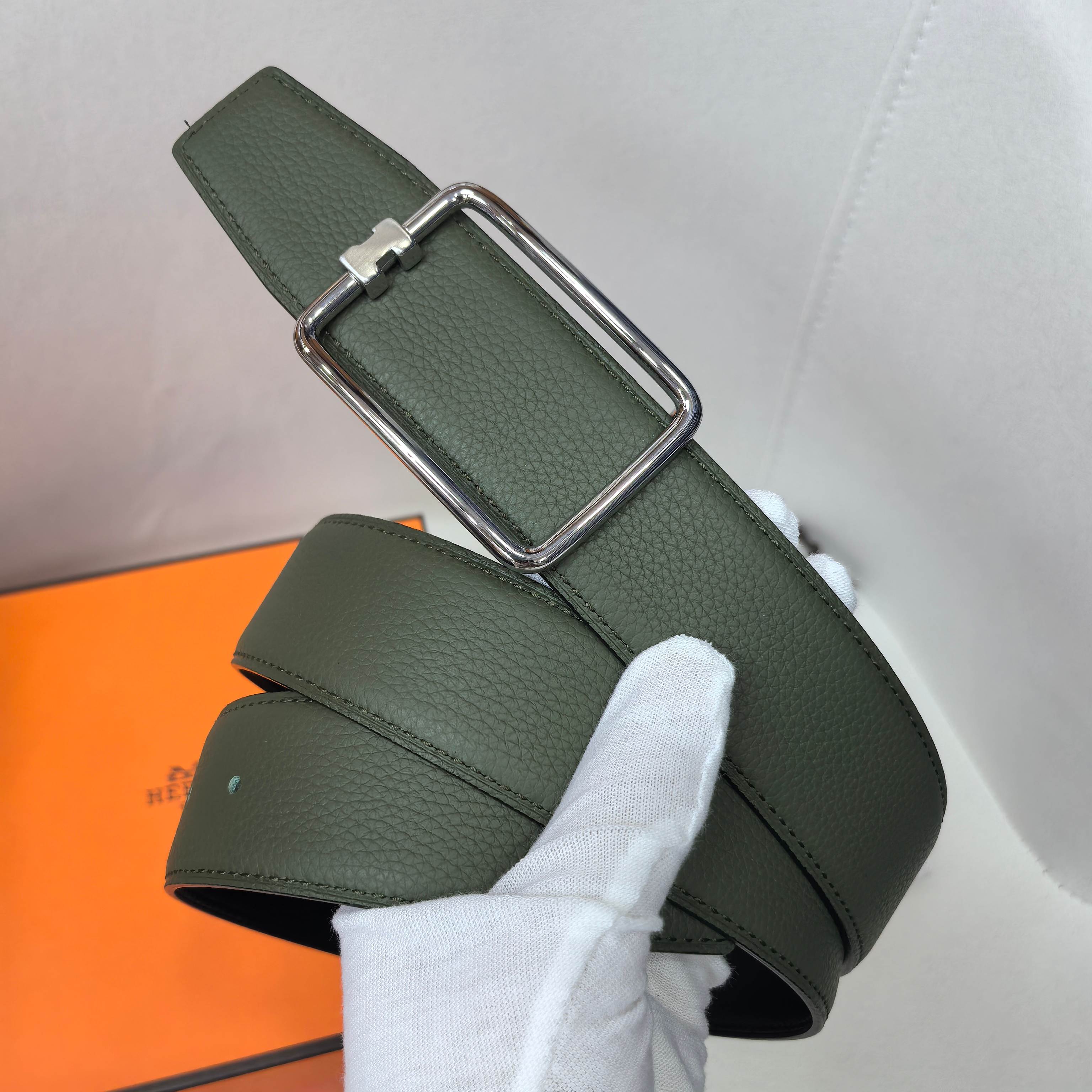 Green leather belt with rectangular silver buckle and prong