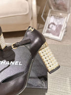 Women's black heeled sandal with gold pearl-studded heel and CC-style charm