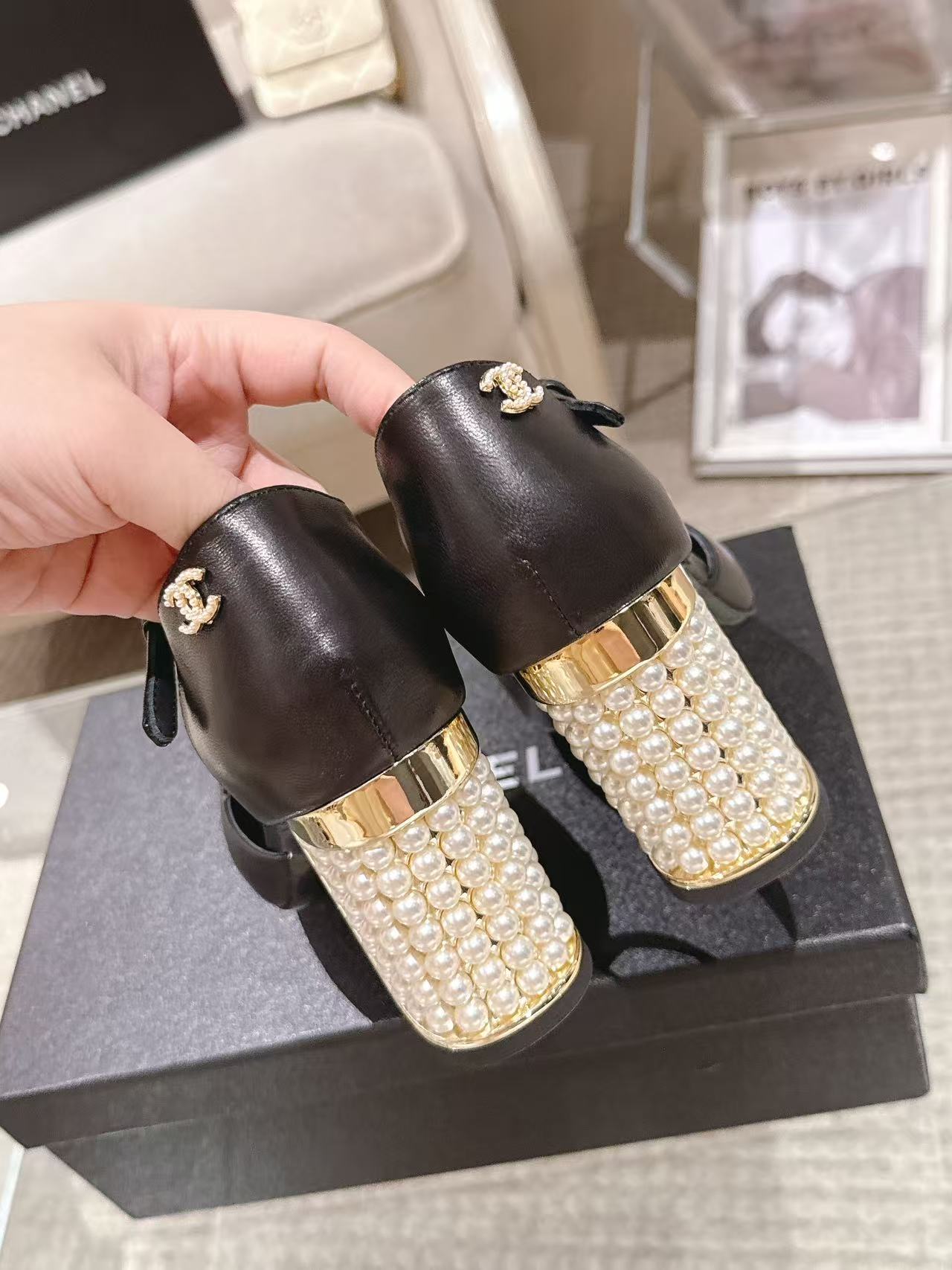 Women's black heeled sandals with gold pearl-studded heel and small bow charm
