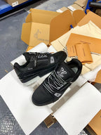 Black Louis Vuitton trainer shoes in open box with patterned laces