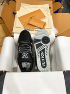 Front view of black Louis Vuitton trainer shoes with VUITTON outsole detail