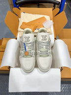 White Louis Vuitton trainer shoes pair, front view with LV medallion detail.