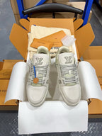 White Louis Vuitton trainer shoes, front view with blue lace detail.