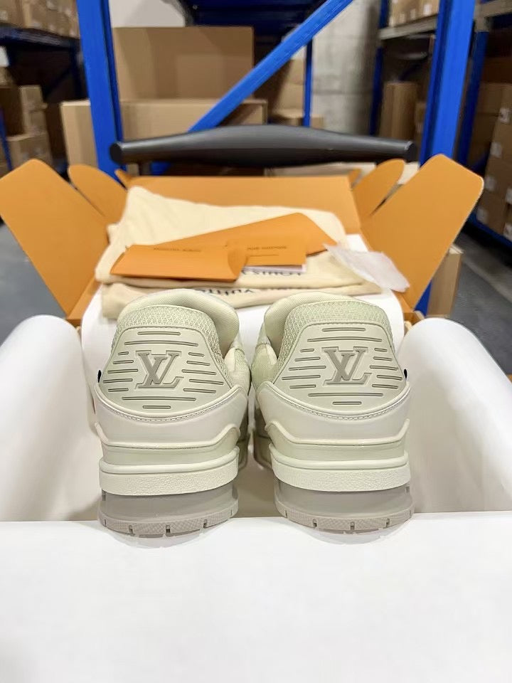 White Louis Vuitton trainer shoes, heel view with raised LV lettering.